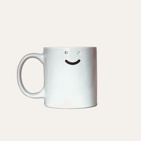 a smiley face mug with holes for the eyes